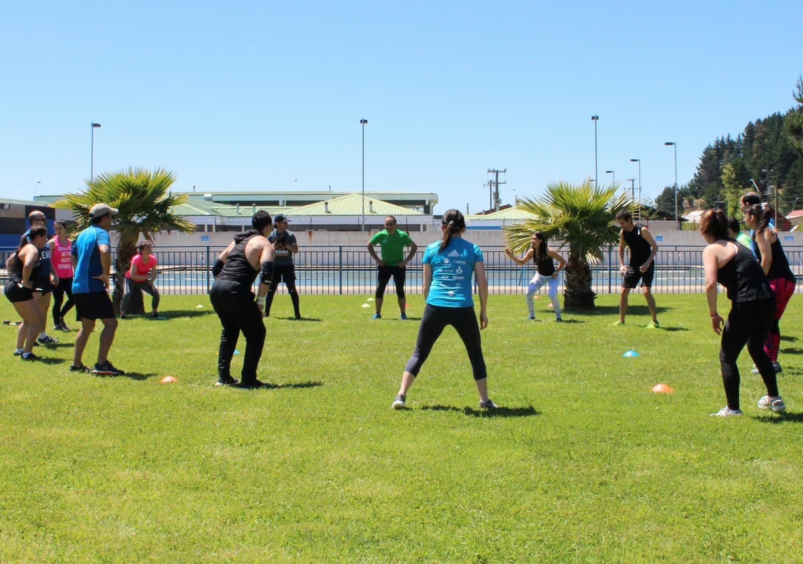Groep sporters doet een bootcamptraining op een grasveld met pionnen